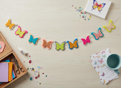 Close-up of handmade multicoloured felt butterflies on a white cord