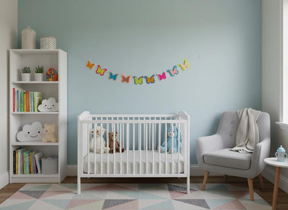 Colourful felt butterfly garland displayed in a light blue nursery