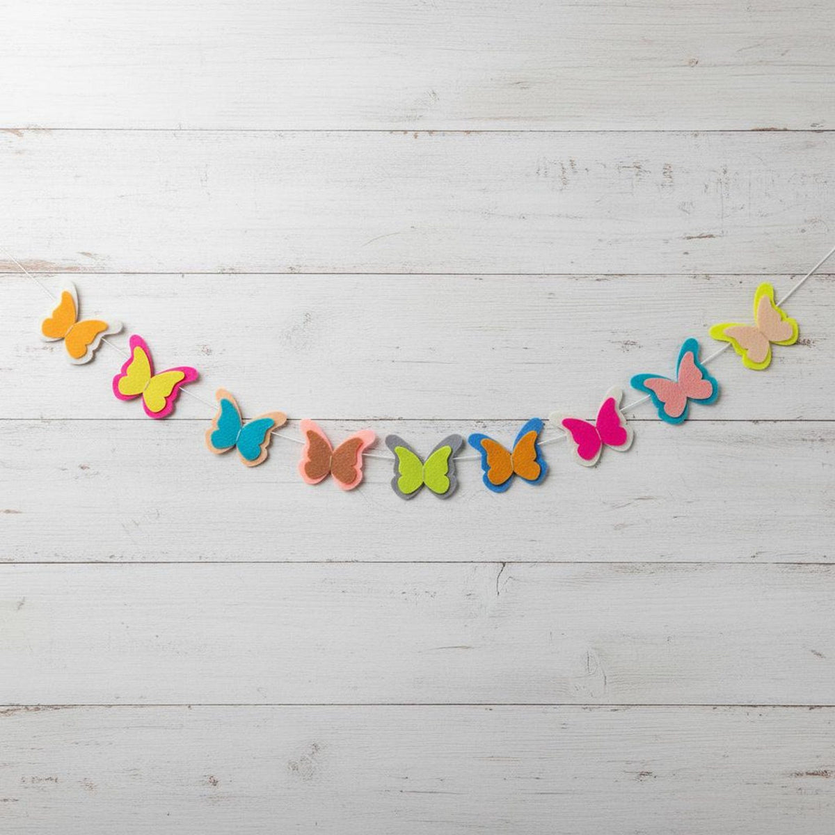 Colourful layered felt butterflies on a white hanging cord