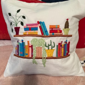 Shelley’s customer photo of the hand-embroidered bookshelf cushion